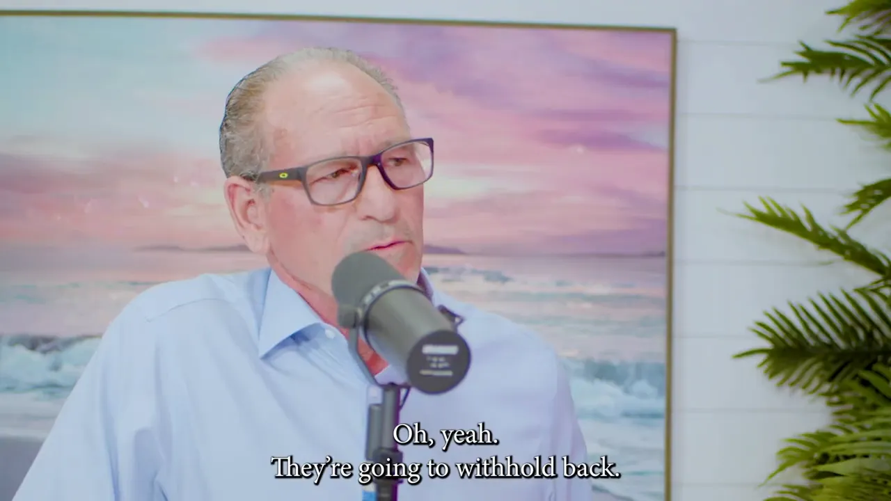Man speaking into a microphone with subtitle 'Oh, yeah. They're going to withhold back.'
