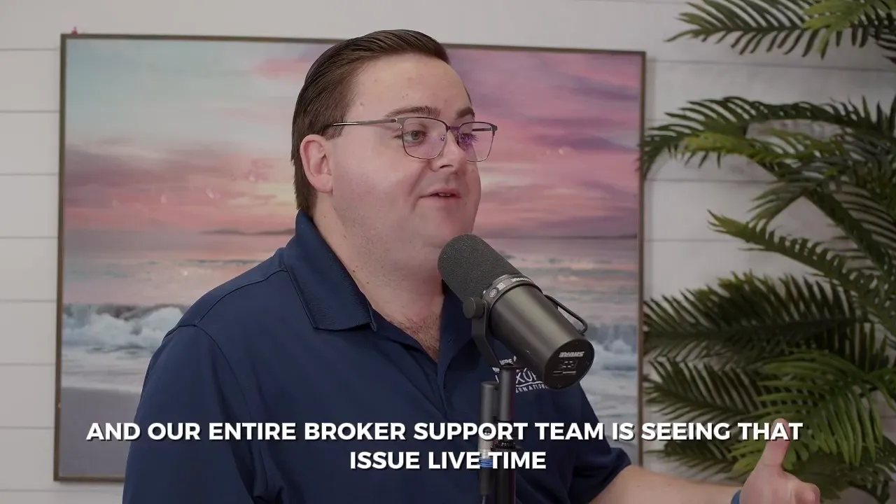 Male speaker gesturing while speaking into a microphone with on-screen caption 'SO WHEN AGENTS CALL IN OUR ENTIRE COMPLIANCE TEAM'.
