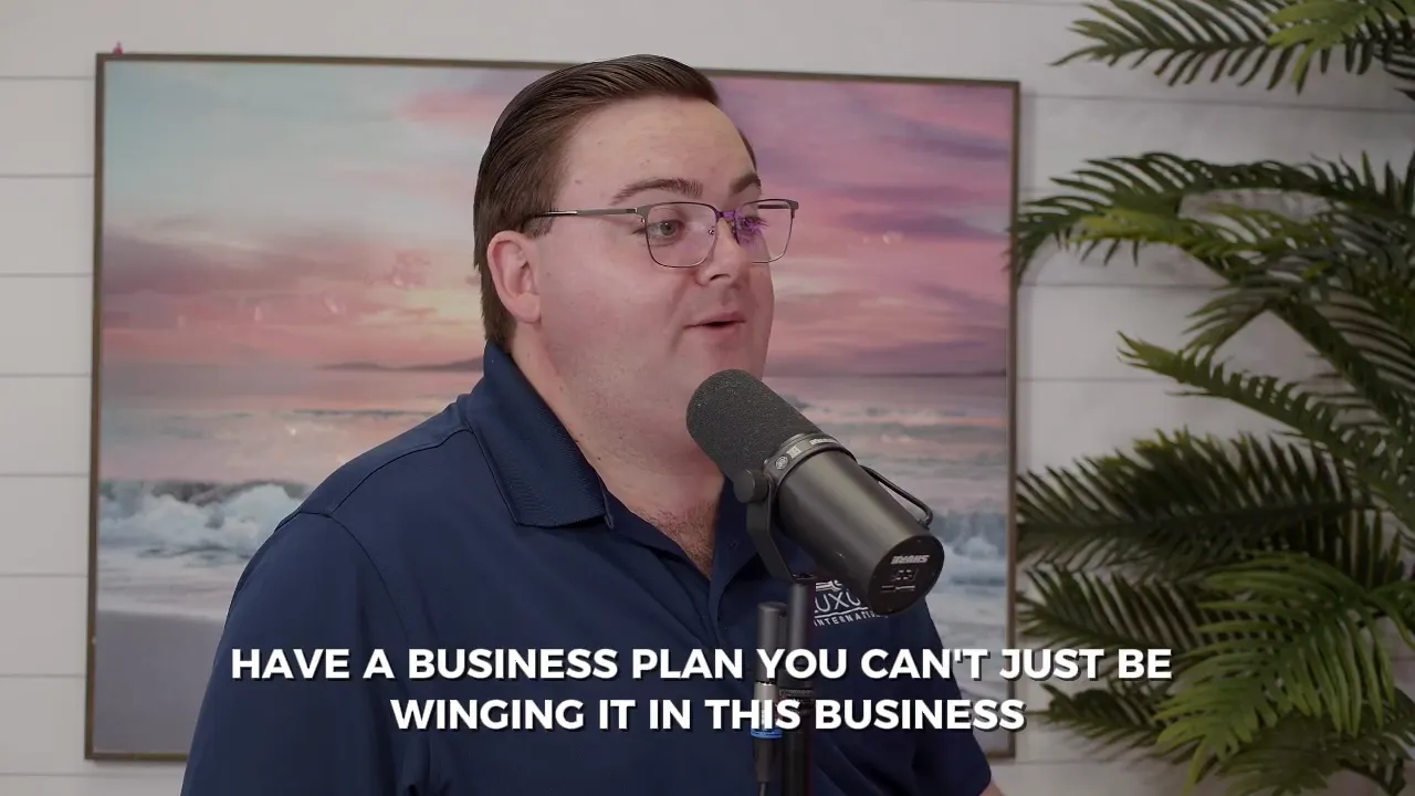 Person speaking into a podcast microphone with the on-screen caption 'HAVE A BUSINESS PLAN YOU CAN'T JUST BE WINGING IT IN THIS BUSINESS'.