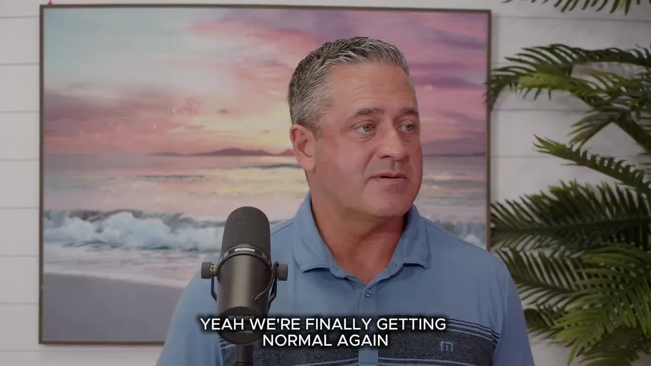 Speaker in a studio with a microphone and subtitle reading 'YEAH WE'RE FINALLY GETTING NORMAL AGAIN', discussing housing market conditions.